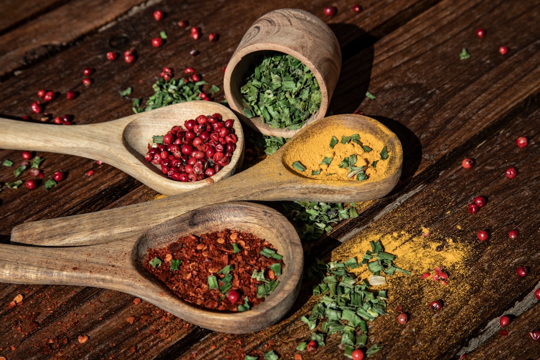 Photo by Angelo Casto three wooden spoons filled with spices on top of a wooden table